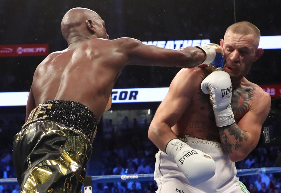 LAS VEGAS, NV - AUGUST 26:  (L-R) Floyd Mayweather Jr. throws a punch at Conor McGregor during their super welterweight boxing match on August 26, 2017 at T-Mobile Arena in Las Vegas, Nevada.  (Photo by Christian Petersen/Getty Images)