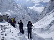 In this Saturday, Jan. 18, 2020 photo, trekkers wait to be airlifted a day after an avalanche hit Mount Annapurna trail in Nepal. Special army and government rescue personnel were searching again on Monday for four South Korean trekkers and their three Nepali guides lost since an avalanche swept a popular trekking route in Nepal's mountains. (AP Photo/Phurba Ongel Sherpa)