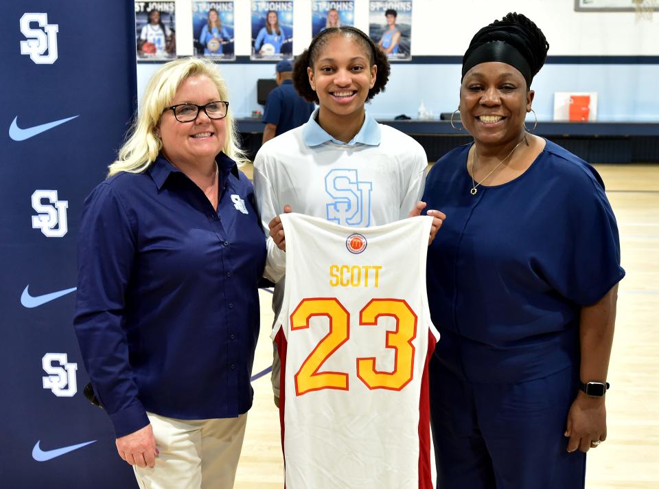 Taliah Scott poses with her McDonald's All-American Jersey with St. Johns Country Day athletic director Traci Livingston and basketball coach Yolanda Bronston after Wednesday's ceremony.