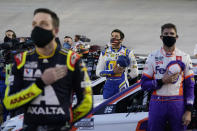 Alex Bowman, left, Chase Elliott, center, and Denny Hamlin listen to the national anthem before the NASCAR Cup Series auto race Saturday, Sept. 19, 2020, in Bristol, Tenn. (AP Photo/Steve Helber)