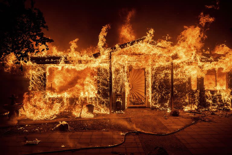 Las llamas consumen una casa en Triangle Rd. mientras el Oak Fire arde en el condado de Mariposa, California, el sábado 23 de julio de 2022. (Foto AP/Noah Berger)