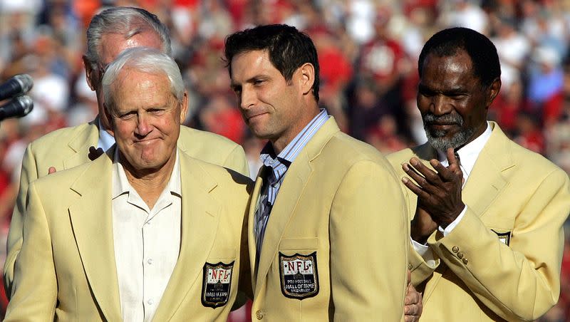 Former San Francisco 49ers quarterback Steve Young, center, stands on stage with former 49ers coach Bill Walsh, left, and former 49ers cornerback Jimmy Johnson during a halftime ceremony honoring Young’s induction into the Pro Football Hall of Fame on Nov. 20, 2005.