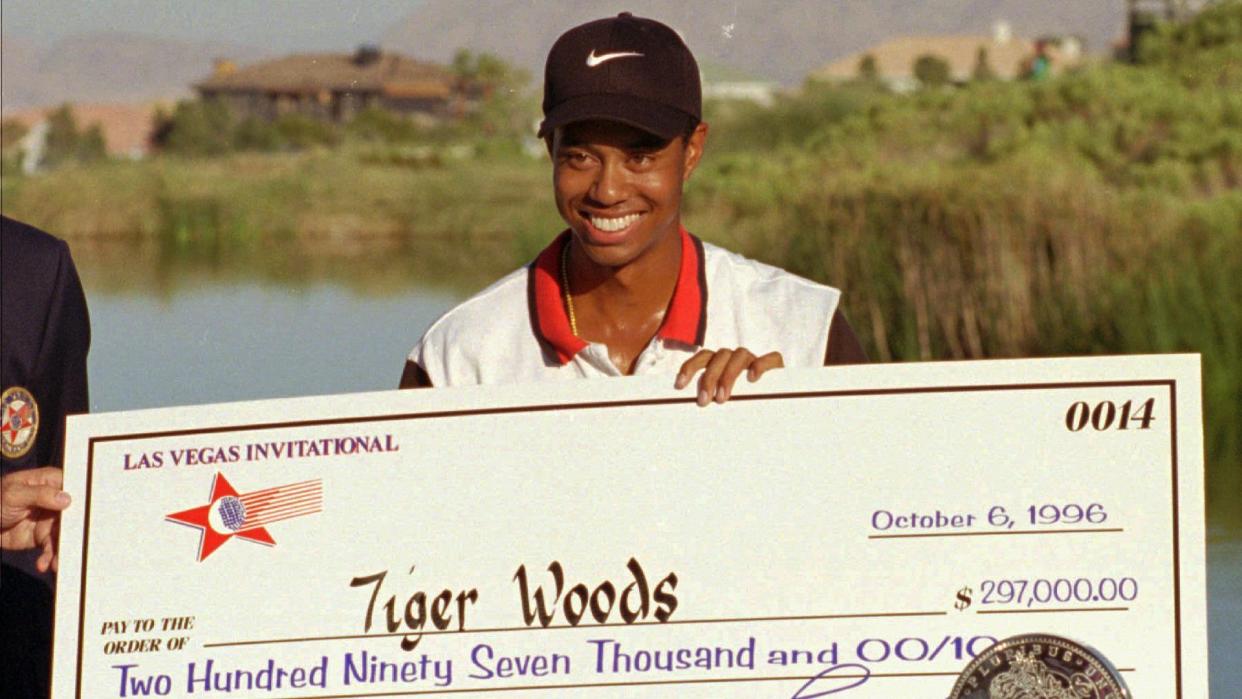 Mandatory Credit: Photo by Lennox Mclendon/AP/Shutterstock (6518354a)WOODS Rookie pro golfer Tiger Woods smiles after receiving a check and trophy for winning the Las Vegas Invitational, at the TPC at Summerlin in Las Vegas.