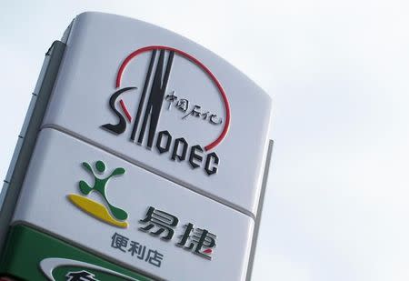 A Sinopec logo is seen on top of a logo of Easy Joy store at a gas station in Beijing, September 16, 2011. REUTERS/Sean Yong