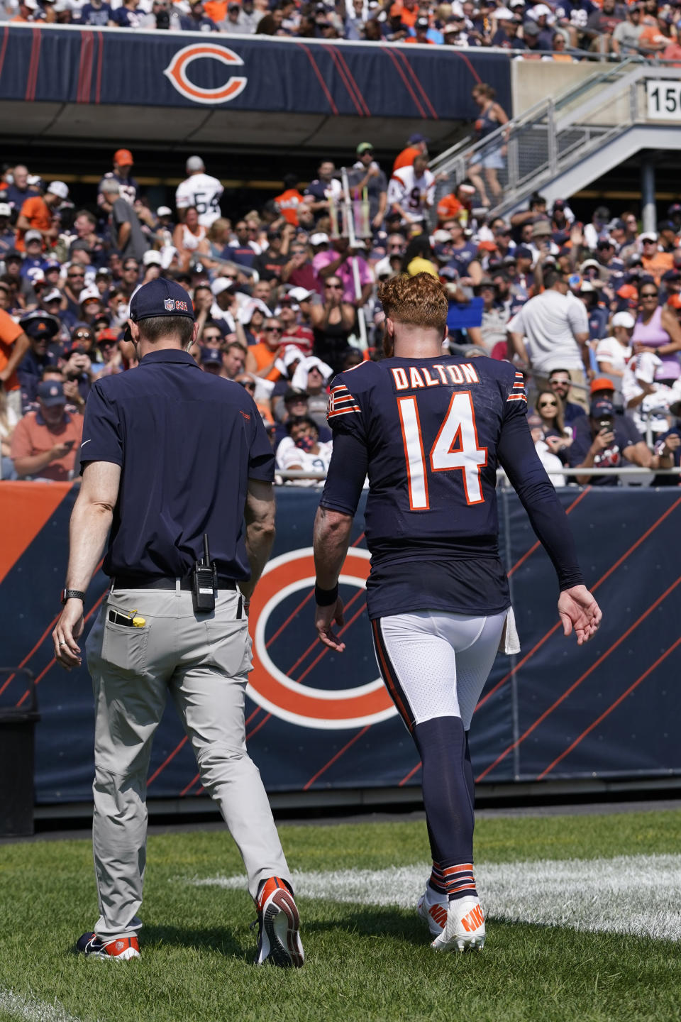 Chicago Bears quarterback Andy Dalton walks to the locker room with an unidentified trainer during the first half of an NFL football game against the Cincinnati Bengals Sunday, Sept. 19, 2021, in Chicago. (AP Photo/Nam Y. Huh)