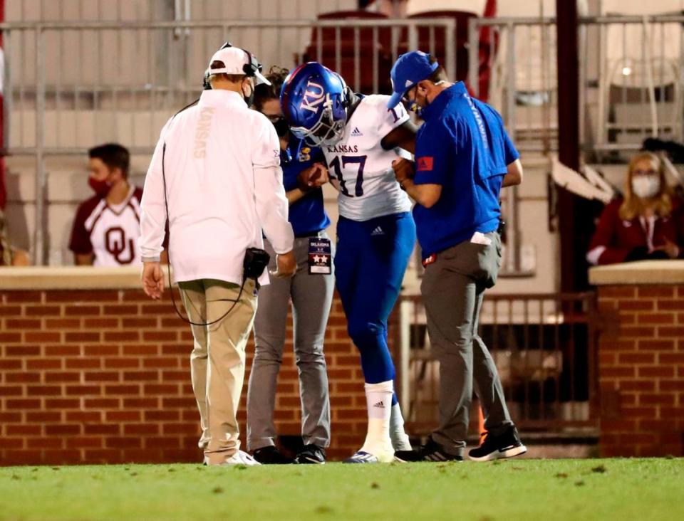 Kansas coach Les Miles checks on injured quarterback Jalon Daniels (17) after he took his ninth sack against the Oklahoma Sooners at Gaylord Family-Oklahoma Memorial Stadium on Nov. 7, 2020.