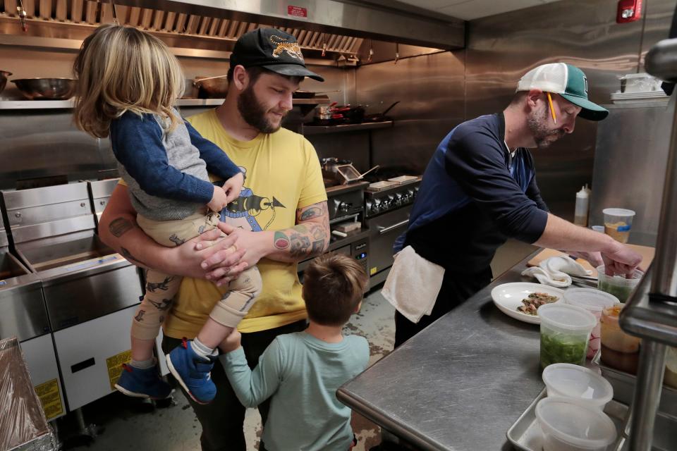 Joshua Lemaire and his sons, Eli Lemaire, 2, and Sam Lemaire, watch chef Chris Cronin prepare some oysters Rockefeller inside his newly opened Union Flats Seafood Company restaurant at 37 Union St. in downtown New Bedford.