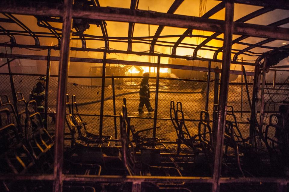 Fire Fighter attempt to put out a building that was set on fire during riots in Baltimore, USA on April 27, 2015. Protests following the death of Freddie Gray from injuries suffered while in police custody have turned violent with people throwing debris at police and media and burning cars and businesses. (Photo by Samuel Corum/Anadolu Agency/Getty Images)