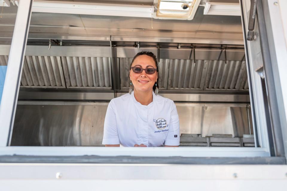 Jocelyn Martinez, the founder of SoulSmile Heath and Wellness, poses at the window of her mobile kitchen trailer on Wednesday, January 12, 2022.