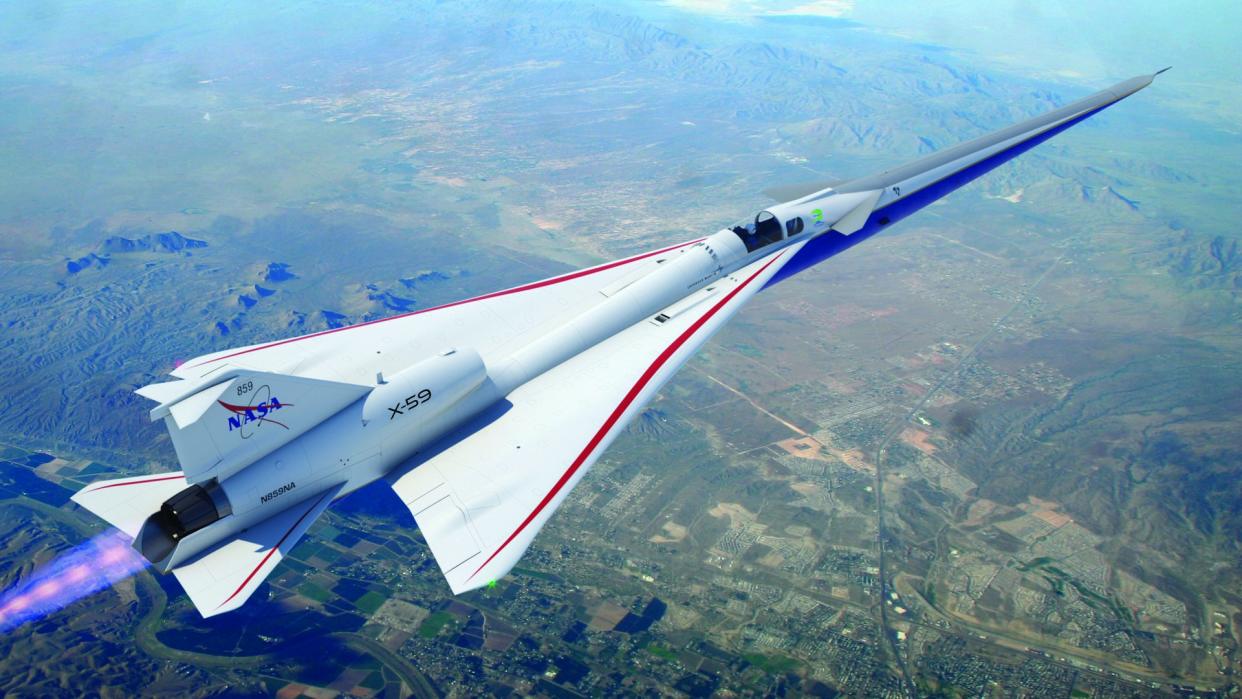  A red, white and blue aircraft with an elongated, sharp nose flies high above a populated area below. 