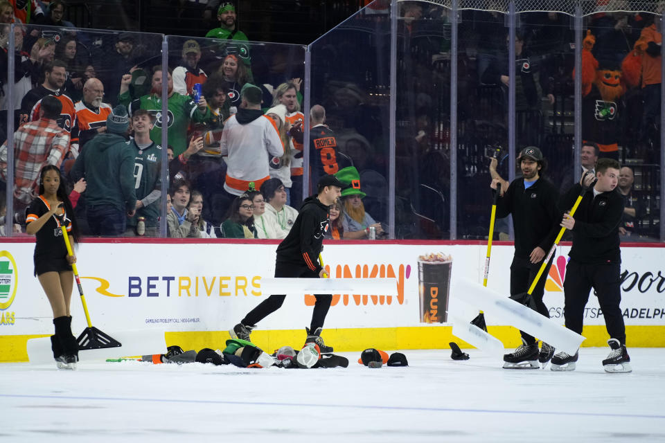 Workers clear the ice of hats after Philadelphia Flyers' Owen Tippett scored his third goal in an NHL hockey game against the Buffalo Sabres, Friday, March 17, 2023, in Philadelphia. (AP Photo/Matt Slocum)