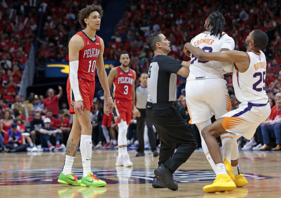 Phoenix Suns forward Jae Crowder (99) is held back by forward Mikal Bridges (25) as he goes after New Orleans Pelicans center Jaxson Hayes (10), who was called for a flagrant-2 foul and ejected, during the first half of Game 3 of an NBA basketball first-round playoff series in New Orleans, Friday, April 22, 2022. (AP Photo/Michael DeMocker)