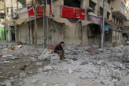 A Palestinian man sits on debris outside a building that was damaged in Israeli air strikes, in Gaza City May 5, 2019. REUTERS/Suhaib Salem