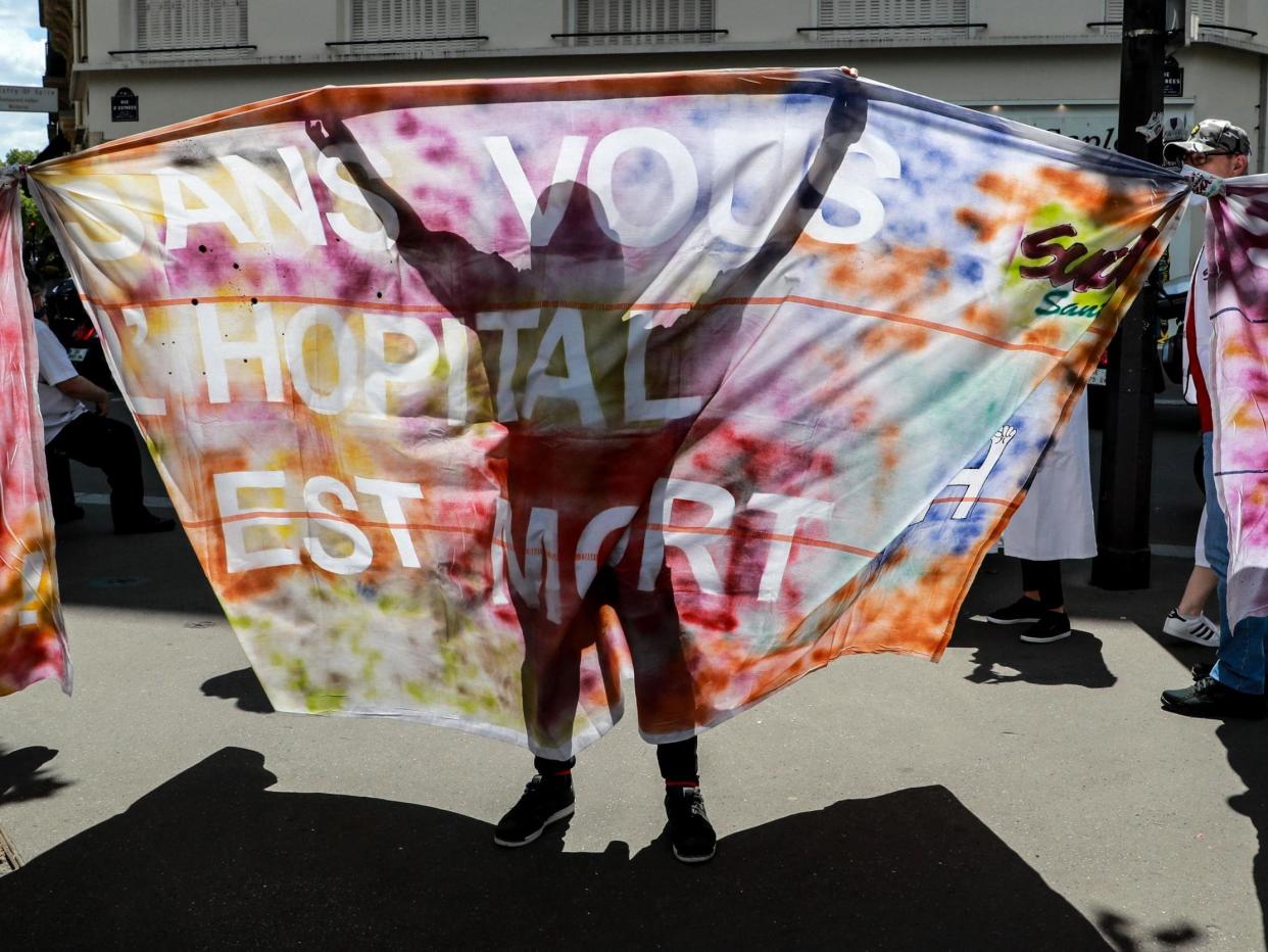 Health workers and trade unions representatives hold a banner reading 'without you, hospital is dead' during a demonstration next to the Health Ministry in Paris: Ludovic Marin/AFP via Getty Images