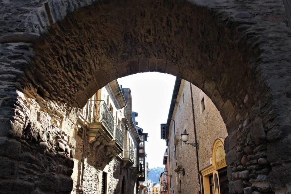 Una callejuela en Ponferrada con arco de piedra antiguo.
