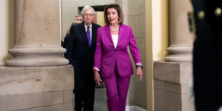 Mitch McConnell walking behind Nancy Pelosi