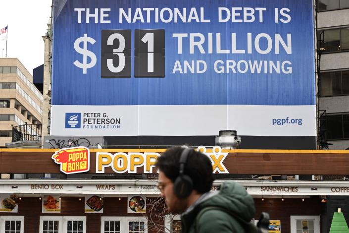 A billboard reads: The national debt is $31 trillion and growing.