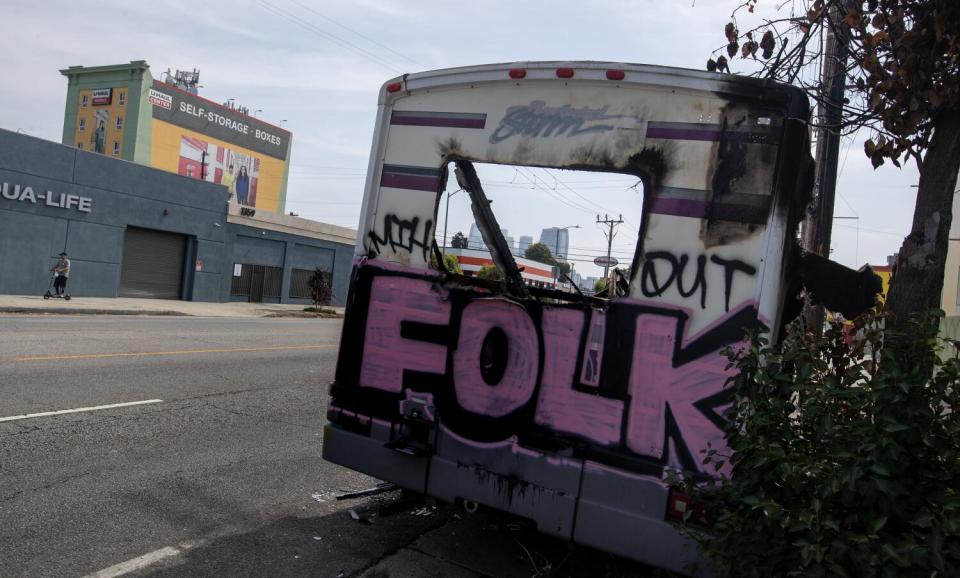 Graffiti on the hulking frame of a burned out RV