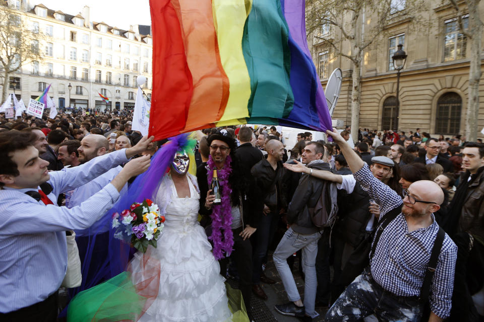 People gather to celebrate the passage of a law allowing same-sex couples to marry and adopt children, in Paris April 23, 2013. French lawmakers passed a bill on Tuesday, a flagship reform pledge by French President which sparked often violent street protests and a rise in homophobic attacks. The law legalises gay marriage and gives gay and lesbian couples adoption rights. Sign reads, "Yes to Equality".   REUTERS/Charles Platiau  (FRANCE - Tags: POLITICS SOCIETY)