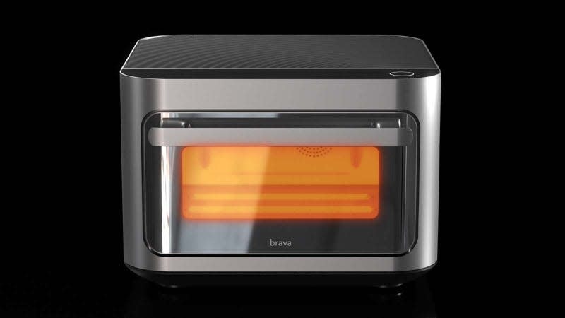 The Brava Glass smart oven with the visible interior glowing orange against a black background.