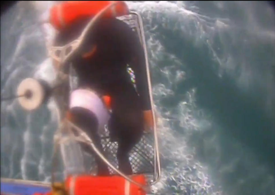 In this Saturday, Dec. 21, 2019, image taken from video released by the U.S. Coast Guard, a man, wearing a full-body wetsuit, is hoisted up from a boat into a helicopter near Santa Rosa Island, one of the Channel Islands in Southern California. A shark reportedly bit the surfer Saturday afternoon in a "truly terrifying situation," the Coast Guard said. The 37-year-old man had been surfing near Santa Rosa Island, one of the Channel Islands, during the attack, according to a news release. (U.S. Coast Guard Los Angeles via AP)