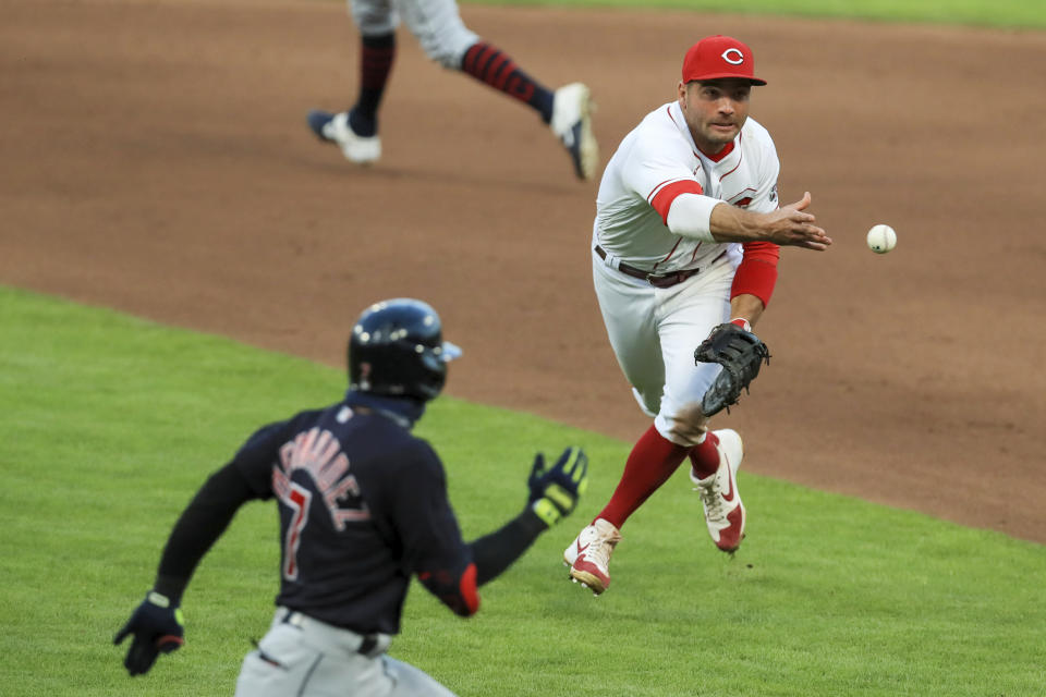 Cincinnati Reds first baseman Joey Votto (19) tosses the ball to first as Cleveland Indians' Cesar Hernandez (7) reaches for an RBI single in the seventh inning of a baseball game in Cincinnati, Tuesday, Aug. 4, 2020. (AP Photo/Aaron Doster)