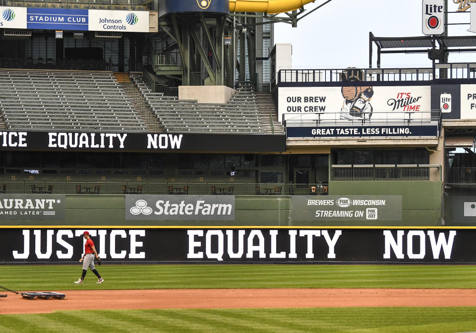 MILWAUKEE, WI - AUGUST 26: A member of the Cincinnati Reds walks off the field as the words "Justice Equality Now" are displayed on the digital marquee in left field at Miller Park after a Major League Baseball game between the Milwaukee Brewers and Cincinnati Reds was postponed on August 26, 2020 as a response by the players of the Milwaukee Brewers to the shooting of Jacob Blake, a 29-year-old Black man by Kenosha, Wisconsin, police on August 19, 2020 .(Photo by Nick Wosika/Icon Sportswire via Getty Images)