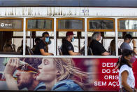 Passengers wear face masks for protection against the new coronavirus while riding on a tram in Lisbon, Portugal, Friday, Aug. 14, 2020. Portuguese health authorities have advised people to wear face masks when using public transport to help stem the spread of COVID-19. (AP Photo/Manu Fernandez)