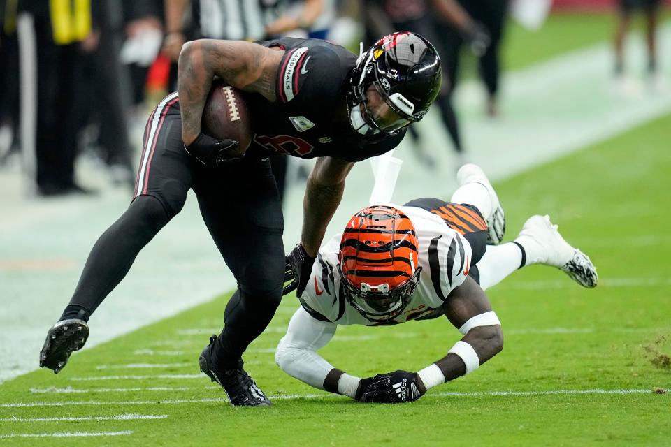 Arizona Cardinals running back James Conner eludes the tackle of Cincinnati Bengals safety Nick Scott, right, during the first half of an NFL football game, Sunday, Oct. 8, 2023, in Glendale, Ariz.