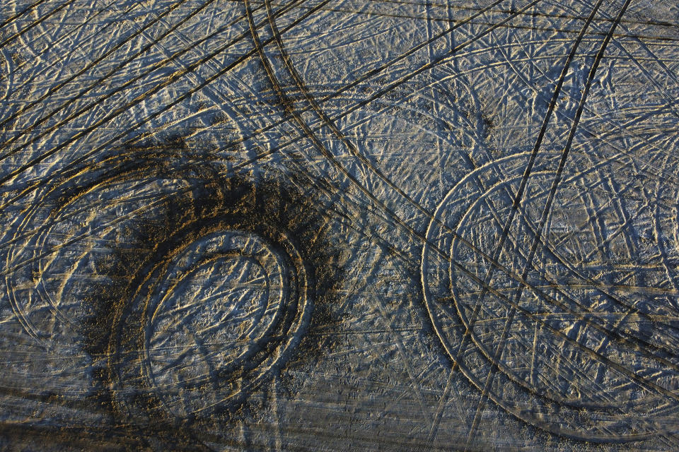 Tire tracks cut through the salt crust on the edge of the Bonneville Salt Flats on Sunday, Oct. 9, 2022, near Wendover, Utah. (AP Photo/Rick Bowmer)