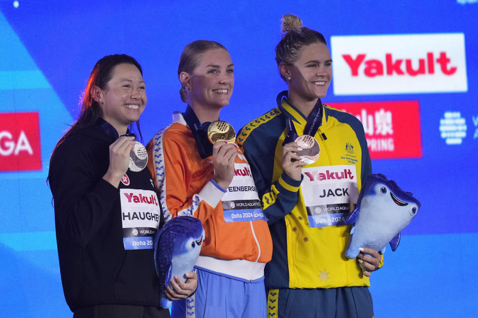 Gold medalist Marrit Steenbergen of the Netherlands, center, silver medalist Siobhan Bernadette Haughey of Hong Kong and bronze medalist Shayna Jack of Australia pose for a photo during the medal ceremony for the women's 100-meter freestyle final at the World Aquatics Championships in Doha, Qatar, Friday, Feb. 16, 2024. (AP Photo/Lee Jin-man)