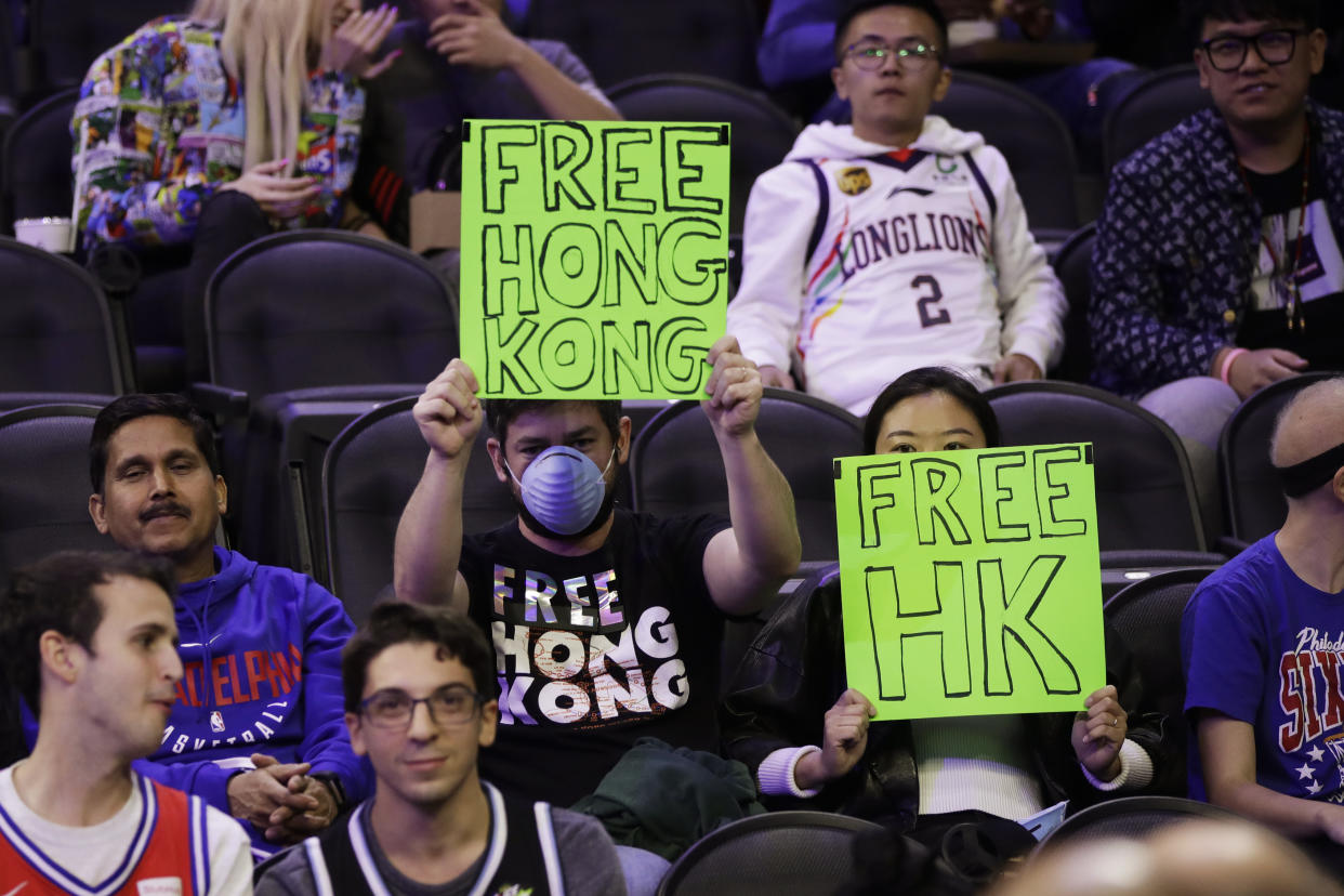 Fans hold signs ahead of a an NBA exhibition basketball game between the Philadelphia 76ers and the Guangzhou Loong-Lions on Tuesday, Oct. 8, 2019, in Philadelphia. (AP Photo/Matt Rourke)