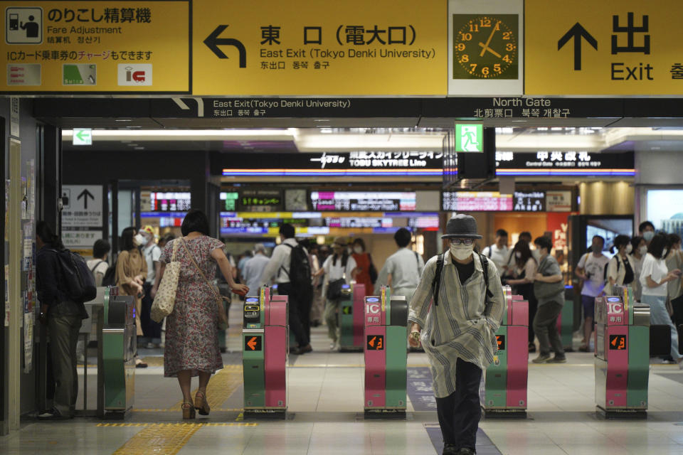 Passengers pass through the gates of a subway station in Tokyo, Friday, Aug. 6, 2021. A man stabbed four passengers with a knife on a Tokyo subway on Friday and was arrested by police after fleeing, a railway official and news reports said. (AP Photo/Kantaro Komiya)