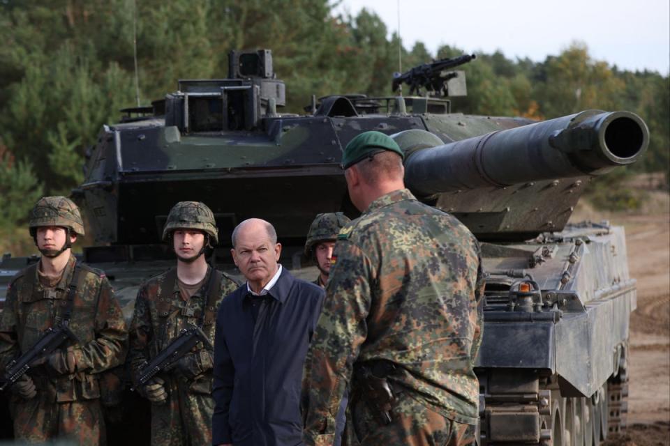 This file photo shows German Chancellor Olaf Scholz (C) talking with soldiers in front of a Leopard 2 main battle tank (AFP via Getty Images)