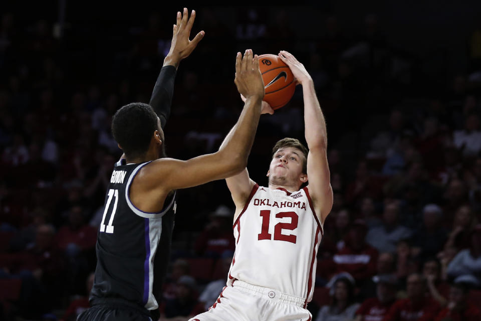 Oklahoma guard Austin Reaves (12) shoots as Kansas State forward Antonio Gordon (11) defends in the second half of an NCAA college basketball game in Norman, Okla., Saturday, Jan. 4, 2020. (AP Photo/Sue Ogrocki)