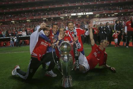 Benfica's players celebrate with the trophy after beating Olhanense and winning the Portuguese Premier League title at Luz stadium in Lisbon April 20, 2014. REUTERS/Hugo Correia