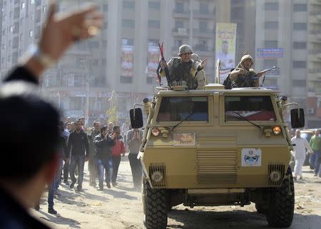 Army soldiers take their positions with their armoured personnel vehicles during clashes with supporters of Muslim Brotherhood and ousted Egyptian President Mohamed Mursi in the Cairo suburb of Matariya November 28, 2014. REUTERS/Mohamed Abd El Ghany