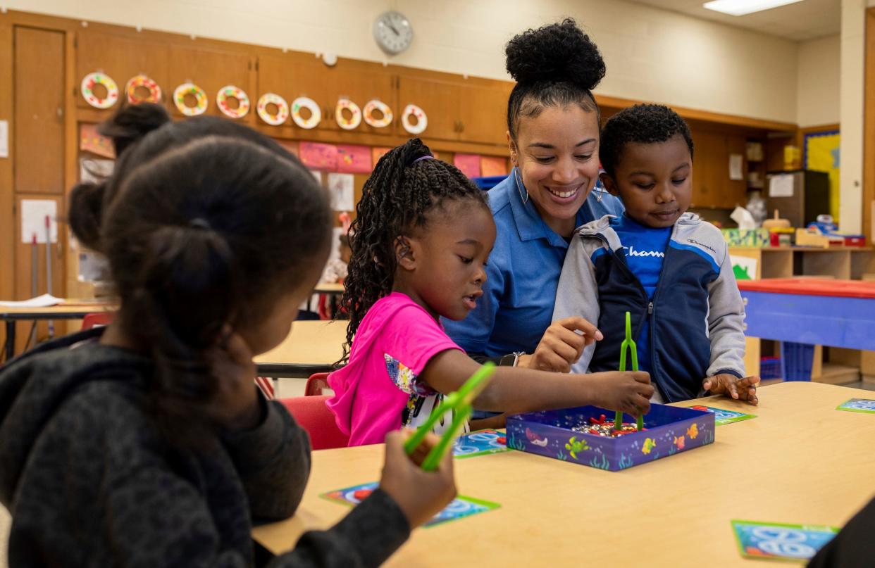 Kacey Stewart, a teacher for Bottles-N-Backpacks, leads number lessons to her students, Savannah Lucas and Xion Yarbrough, inside the Chapelle Business Center in Ypsilanti on Friday, Dec. 8, 2023.