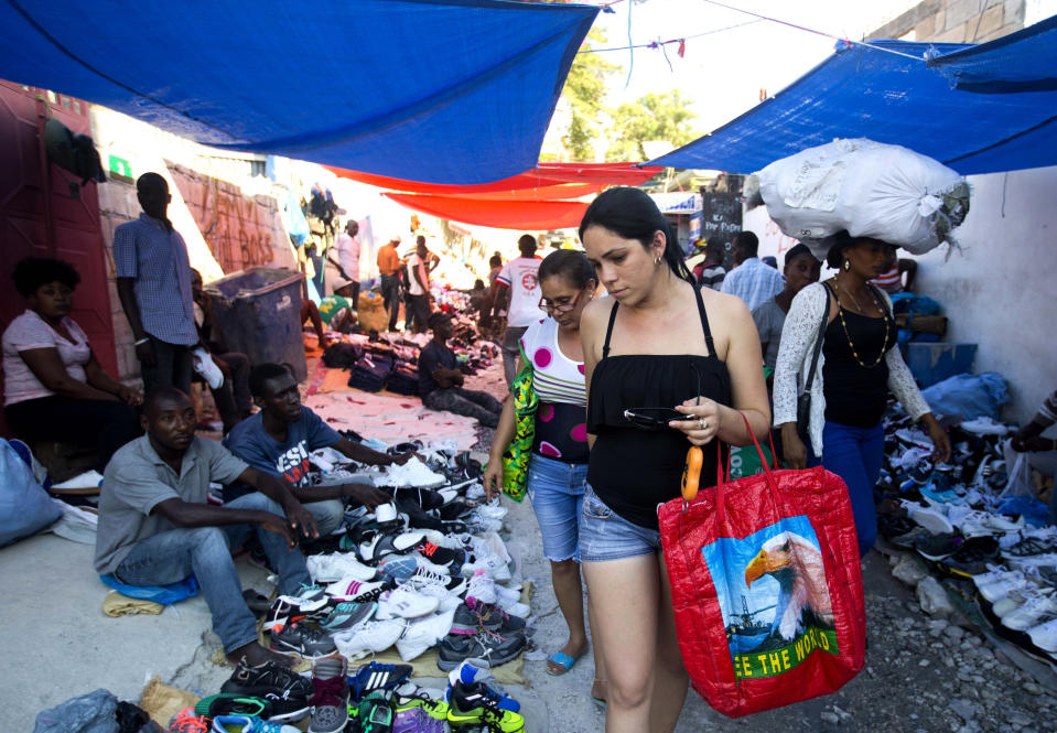 Cuban women shop at a street market in Port-au-Prince, Haiti, Thursday, Dec. 6, 2018. The “Cuban market” in Port-au-Prince is part of a global trade, estimated to top $2 billion, fed by the confluence of Cubans’ increased freedom to travel with the communist state’s continued domination of the economy back home. (AP Photo/Dieu Nalio Chery)