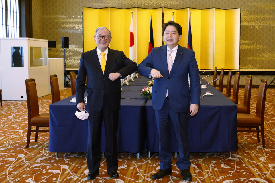 Philippine Foreign Secretary Teodoro Locsin Jr., left, and Japanese Foreign Minister Yoshimasa Hayashi pose for the cameras at the Iikura Guest House in Tokyo, Japan on Saturday, April 9, 2022. (Rodrigo Reyes Marin/Pool Photo via AP)