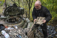 A Ukrainian serviceman holds his body armour on the top of Ukrainian Soviet-made T-64 tank in Bakhmut, Ukraine, Sunday, Oct. 2, 2022. (AP Photo/Inna Varenytsia)