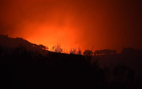 Flames threaten to crest a hilltop near Sonoma - Credit: AFP