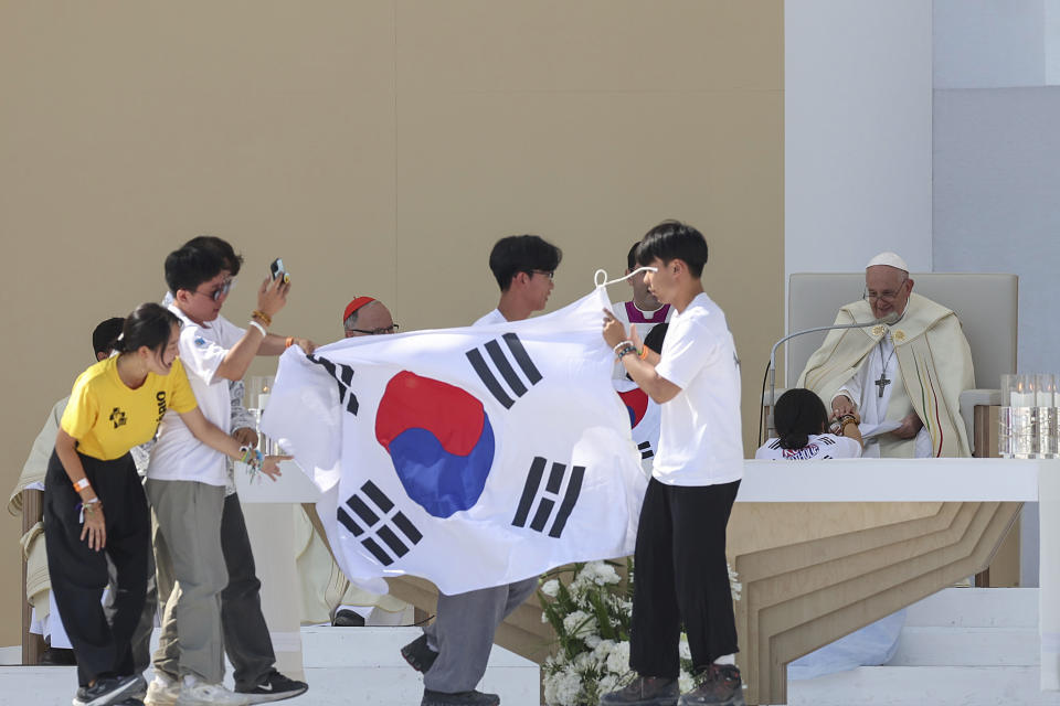 Young pilgrims from South Korea celebrate with their national flag with Pope Francis after he announced that the next World Youth Day, will be in Seoul, South Korea in 2027, at the end of a mass at Parque Tejo in Lisbon, Sunday, Aug. 6, 2023. An estimated 1.5 million young people filled the parque on Saturday for Pope Francis' World Youth Day vigil, braving scorching heat to secure a spot for the evening prayer and to camp out overnight for his final farewell Mass on Sunday morning. (Inacio Rosa/Pool via AP)