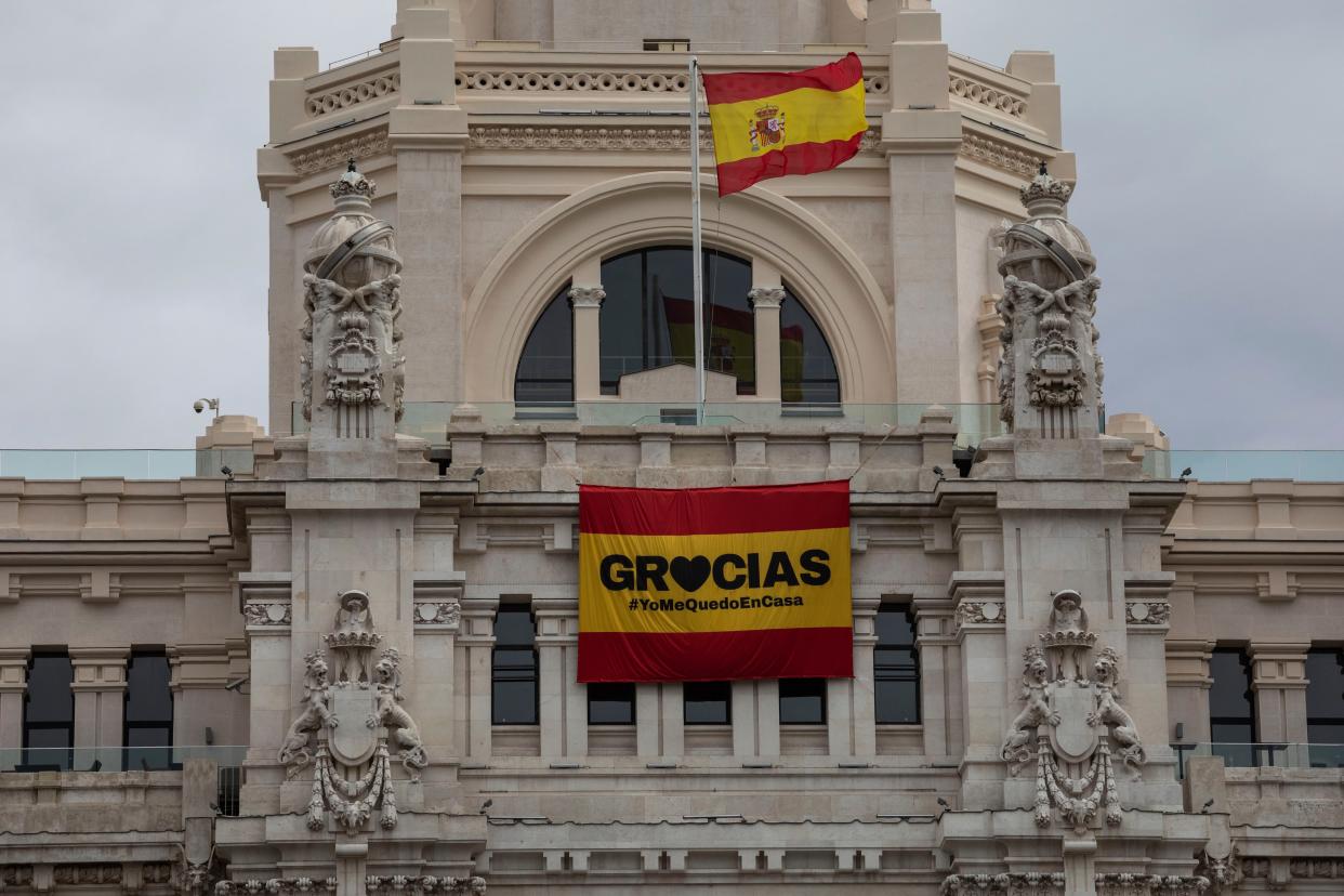 A sign that reads in spanish: "Thank you #IstayAtHome" hangs on the facade of the Madrid city hall, Spain, on Sunday March 22, 2020.