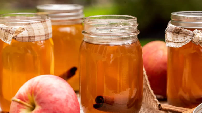 Cider cocktail in mason jars with apples