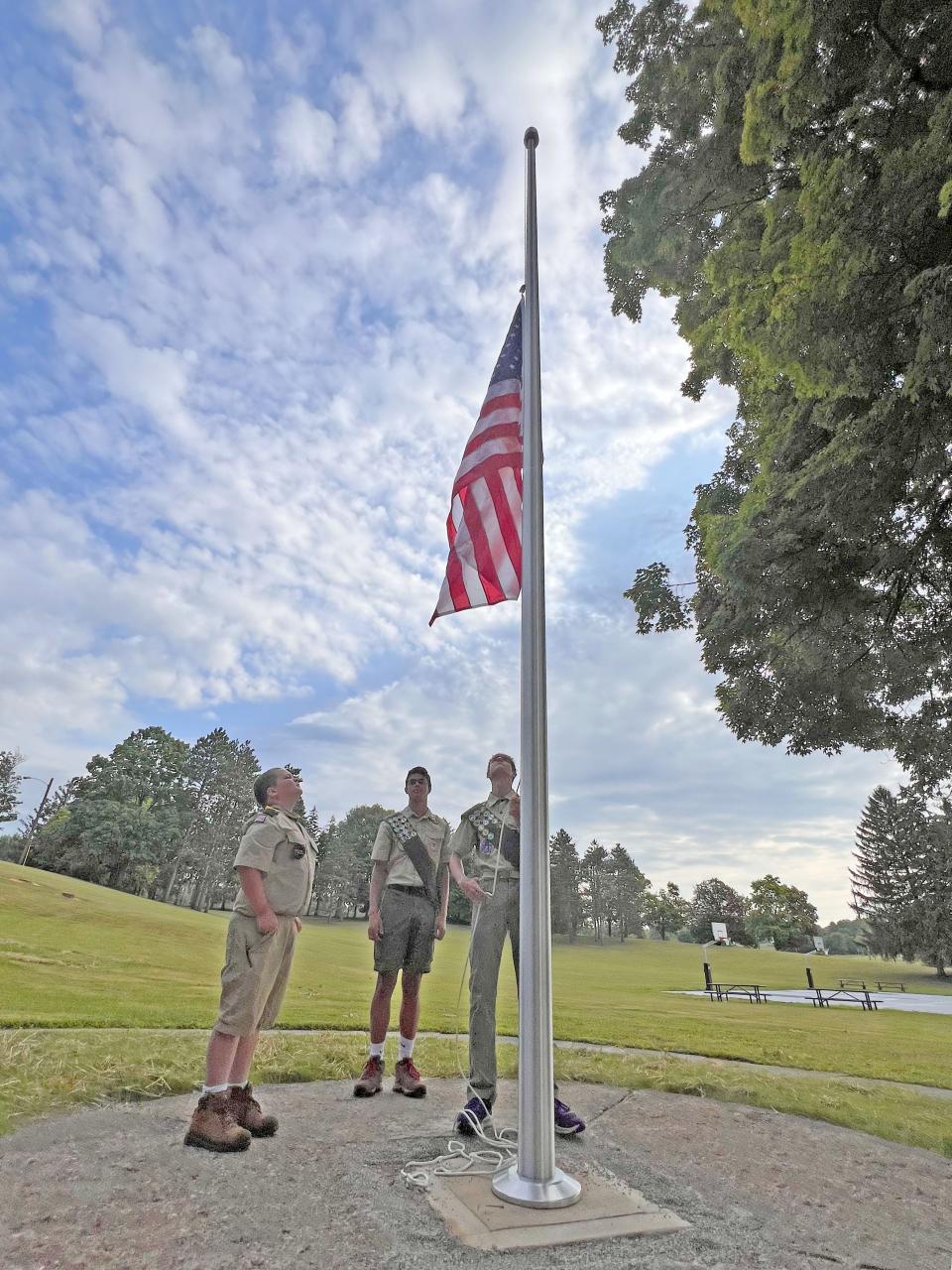 Connor O’Neil, left, David Crundwell and Daniel Craft, all from St. Peter’s Boy Scout Troop 121, raise the flag Friday morning at Liberty Park.