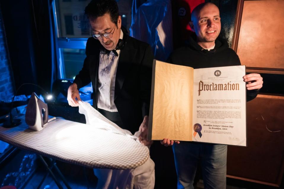 DeWitt admires the proclamation Hook was given from the city for his philanthropic ironing. Stefano Giovannini