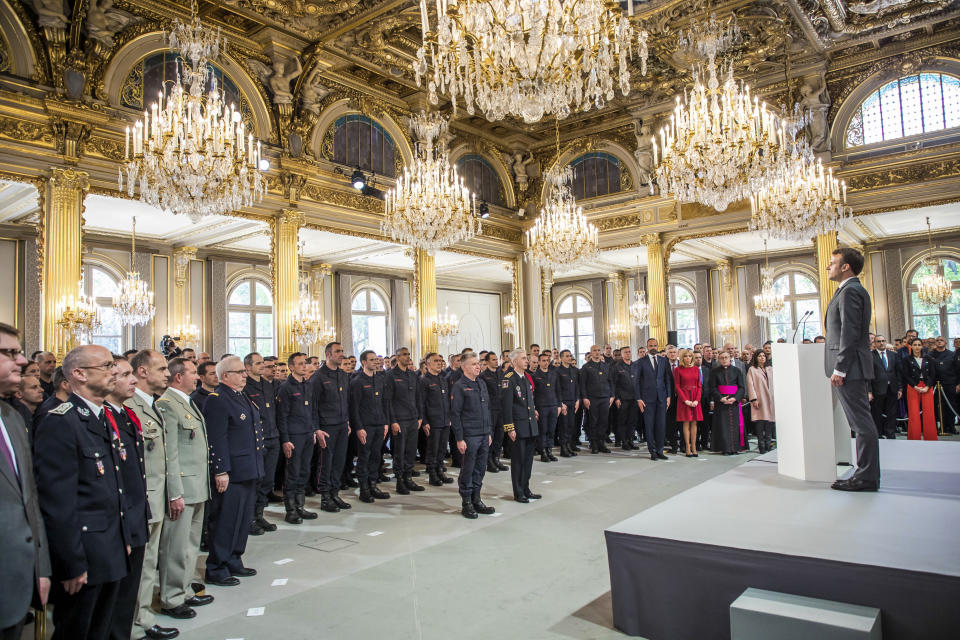 El presidente francés Emmanuel Macron en posición de firmes antes de dirigirse a la brigada de bomberos y fuerzas de seguridad de París que ayudaron a extinguir el incendio en la catedral de Notre Dame en París, en el palacio de Elíseos en París, el jueves 18 de abril de 2019. (Christophe Petit Tesson, Pool vía AP)