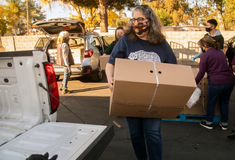 (11/20/20)Anne Swehla Garcia loads a box of frozen turkeys into the back of a SUV at the Food 4 Less on Hammer Lane and Thornton Road in Stockton. Swehla Garcia has been collecting donations for turkeys since 2017. That year she bought 14 turkeys. This year the kindergarten teacher at Julia Morgan Elementary School says she collected $8,890 from 265 people. With the money she purchased nearly 500 turkeys or about 6,500-pounds of the gobblers. Swehla Garcia paid store director with a check then she and a cadre of friends loaded up their vans can pickup trucks and paraded them to the Emergency Food Bank for the organization's annual Thanksgiving food giveaway.  CLIFFORD OTO/THE STOCKTON RECORD