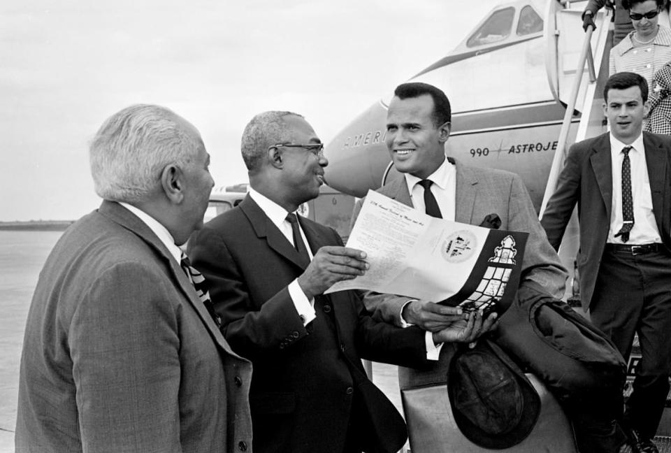 (Left to right) Dr. Arna Bontemps, director of Fisk University affairs, Dr. Stephen J. Wright, president of Fisk University and Harry Belafonte talk on April 26, 1966 after arriving at Nashville Municipal Auditorium. (Credit: Joe Rudis)